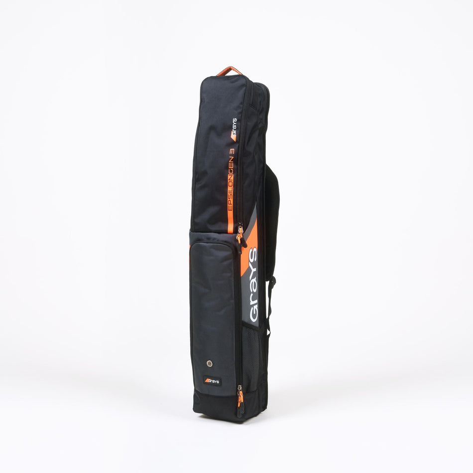 The Grays Epsilon Gen 3 Kitbag is a black rectangular bag with orange accents and the Grays logo in white, featuring a padded stick section for hockey sticks, shown upright on a plain white background.