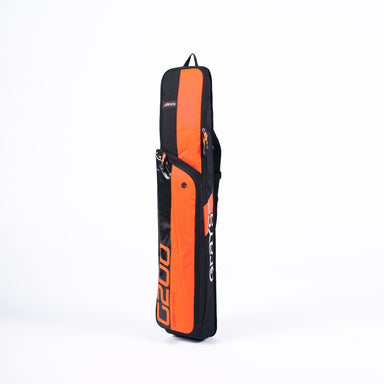The Grays G200 Hockey Stick Bag by Grays, in black and orange, stands upright against a plain white background, showing its ample compartments and dedicated stick section.