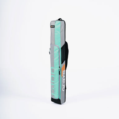 The Grays G100 Hockey Stick Bag, a rectangular teal and gray kit from Grays with a single strap and stick section, stands upright against a plain white background.