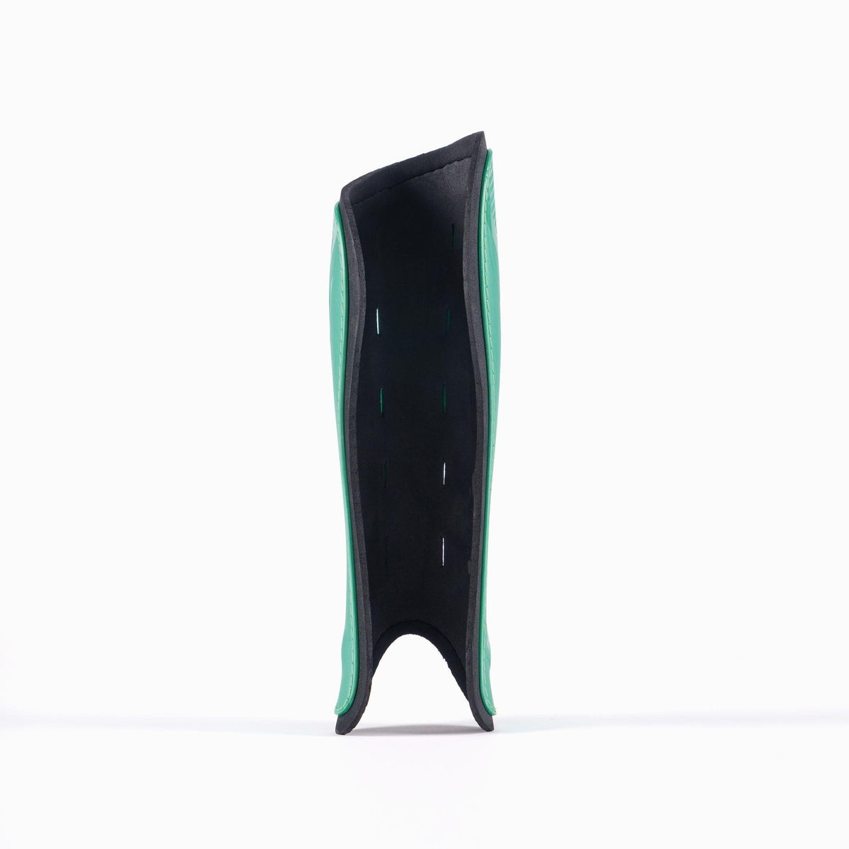 The Grays G600 Hockey Shinguard by Grays, shown upright on a white background with its padded side facing forward, features a green and black design and a lightweight polymer shell for superior impact protection.