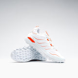 A pair of Grays Raid 2.0 Hockey Shoes by Grays in white are shown: one stands upright, the other leans to display its textured sole and aggressive grip—all set against a plain, light background.