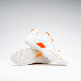 The Grays Stealth 1.0 Hockey Shoes in white, by Grays, are shown on a plain white background—one upright and one on its side to highlight the textured high-performance outsole and orange detailing.