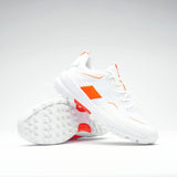 The Grays Aero Cage X Hockey Shoes by Grays are white athletic shoes with bright orange accents and a genius foam midsole for lightweight comfort. Displayed on a plain background, one shoe is upright and the other lies on its side.