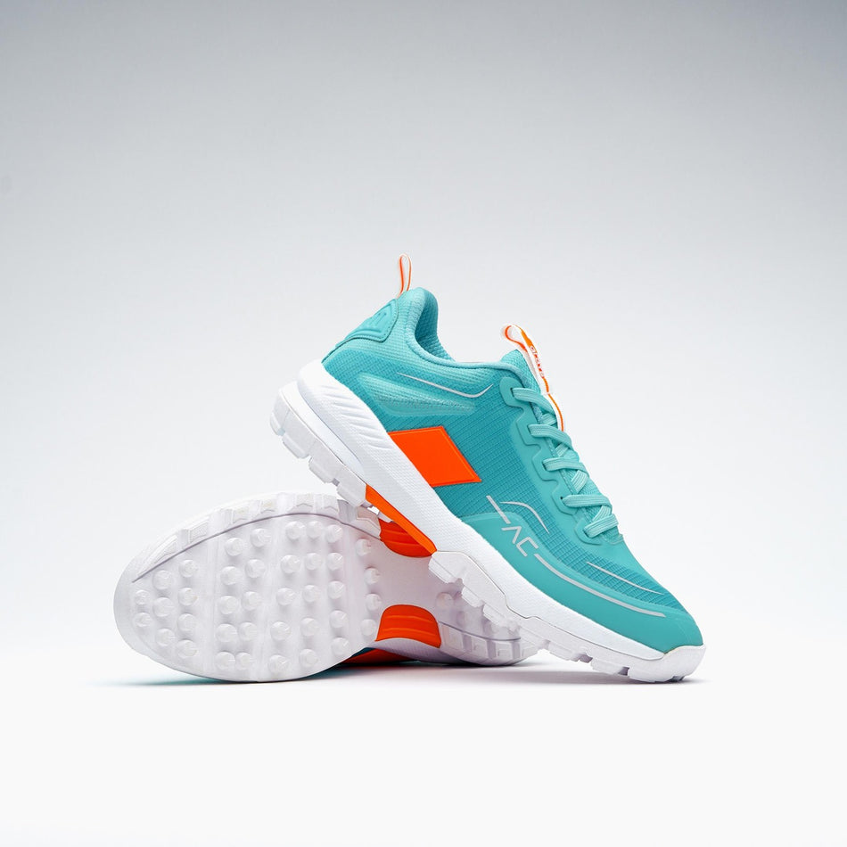 The Grays Aero Cage X Hockey Shoes by Grays feature a teal design with white soles and orange accents, a genius foam midsole for lightweight comfort—one upright, one on its side—displayed against a plain white background.