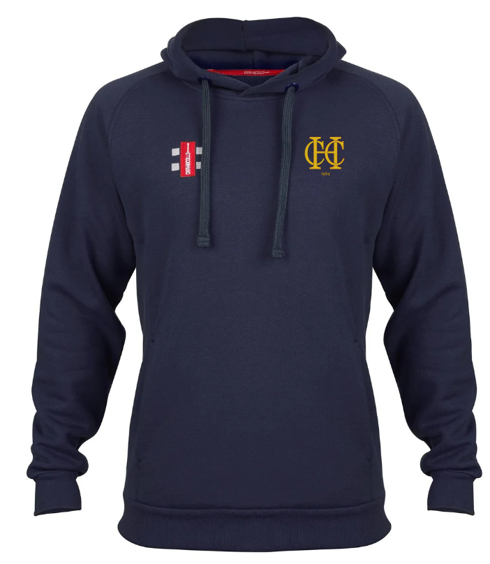 The Hawkesbury Upton CC Velocity Hoodie by Gray Nicolls is a navy organic cotton hoodie featuring a front pouch pocket, drawstrings, a yellow embroidered logo on the left chest, and a small white-and-red patch on the right chest.