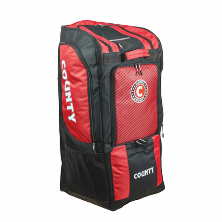 The Hunts County Maximo Large Wheeled Duffle Bag features a spacious red and black design, multiple zippered compartments, wheels for easy transport, and showcases the COUNTY logo on the side and front panel.