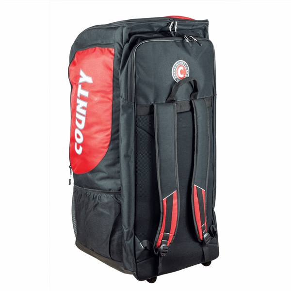 The Hunts County Maximo Large Wheeled Duffle Bag is a spacious black and red bag with "COUNTY" on the side, two adjustable backpack straps, a top handle, and wheels—ideal as a cricket duffle from Hunts County.