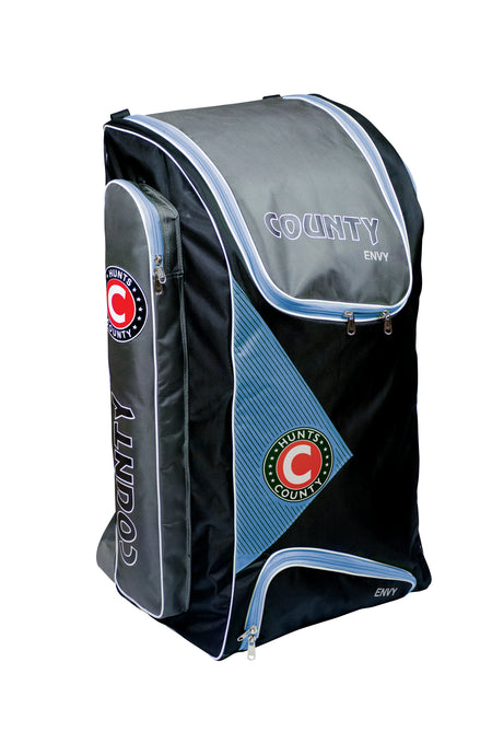 The Hunts County Envy Duffle is a large black and gray cricket bag with blue accents, COUNTY branding, multiple zippered compartments, bat pockets, and a sturdy upright design.