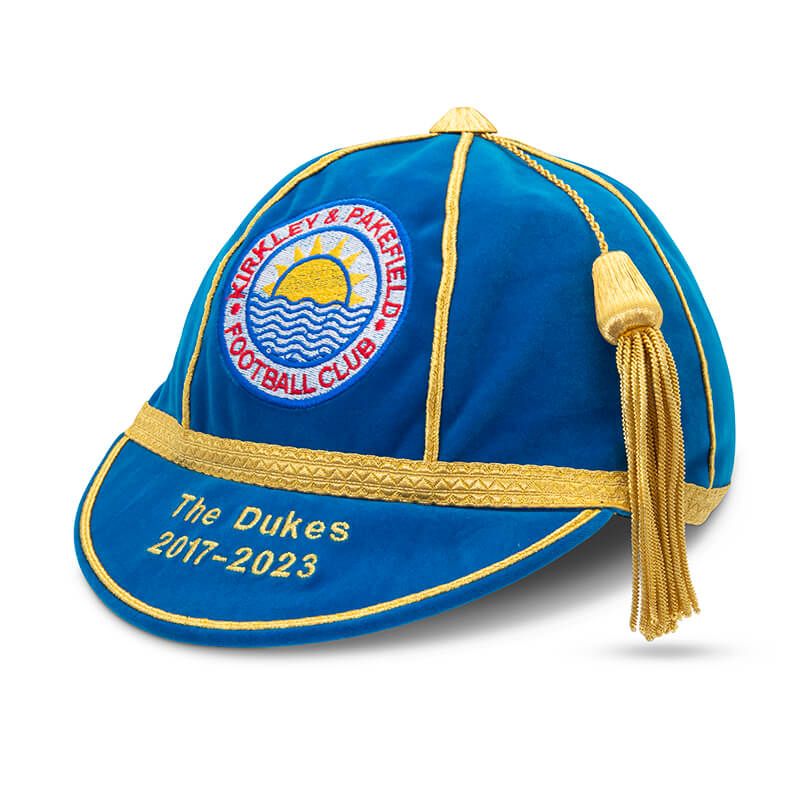 A blue and gold velvet honour cap with tassel, featuring an embroidered Kirkley & Pakefield FC crest and "The Dukes 2017-2023" in gold—part of Martin Berrill Sports' Custom, Honour & Commemorative Caps collection.