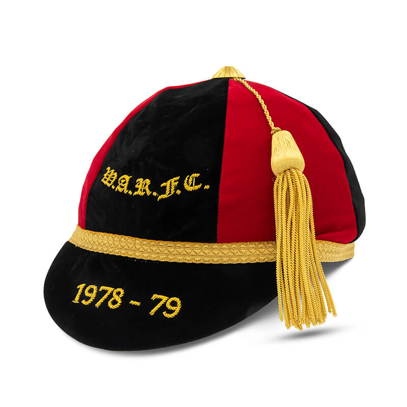 A black and red velvet honour cap by Martin Berrill Sports, with gold trim, tassel, and embroidered "W.A.R.U.F.C." and "1978-79"—a classic commemorative team memento from their Custom, Honour & Commemorative Caps range.