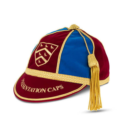 A maroon and blue velvet cap with gold trim, tassel, and an embroidered shield emblem. “PRESENTATION CAPS” in gold on the brim—ideal for commemorative or custom cricket caps by Martin Berrill Sports.