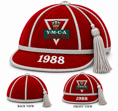 Martin Berrill Sports red velvet honour cap with silver trim and tassel, featuring a Y.M.C.A. Wales emblem and the embroidered year 1988 on the front.