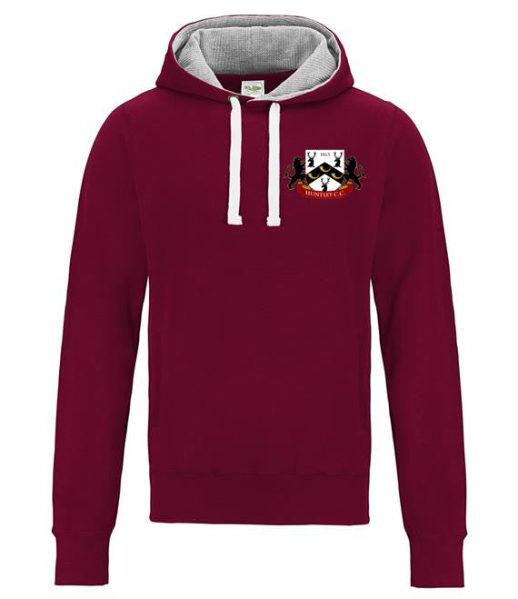The Huntley CC Adult Hoody by Martin Berrill Sports is a maroon cricket hoodie featuring a light gray hood lining, white drawstrings, and a colorful crest with black and gold on the left chest—perfect for club supporters.