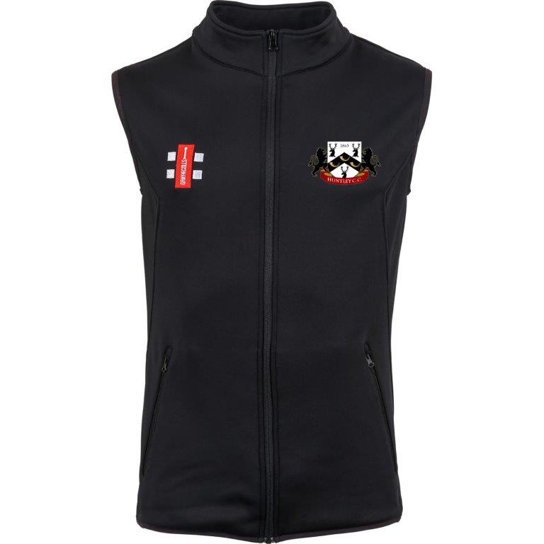 The Huntley CC Black Storm Bodywarmer by Gray Nicolls is a sleeveless zip-up vest with two front pockets, an embroidered lions and shield crest on the left chest, and a red and white Huntley CC logo on the right chest.