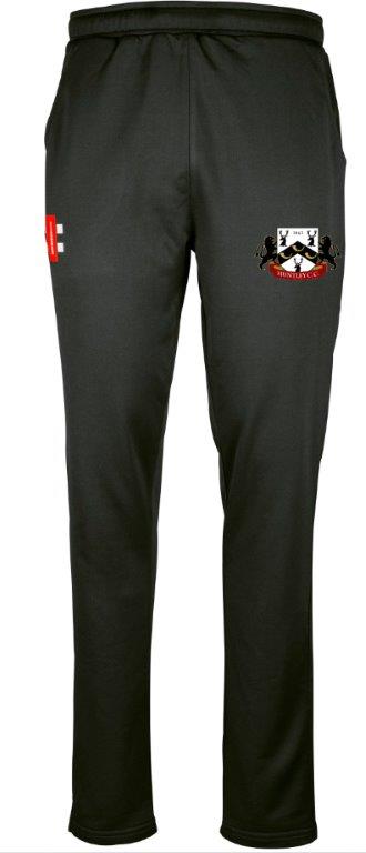 The Gray Nicolls Huntley CC Pro Performance Training Trousers are black joggers with an embroidered crest of two lions and a red banner on the right thigh, plus a small red and white rectangular logo on the left thigh, offering tailored fit, style, and comfort.