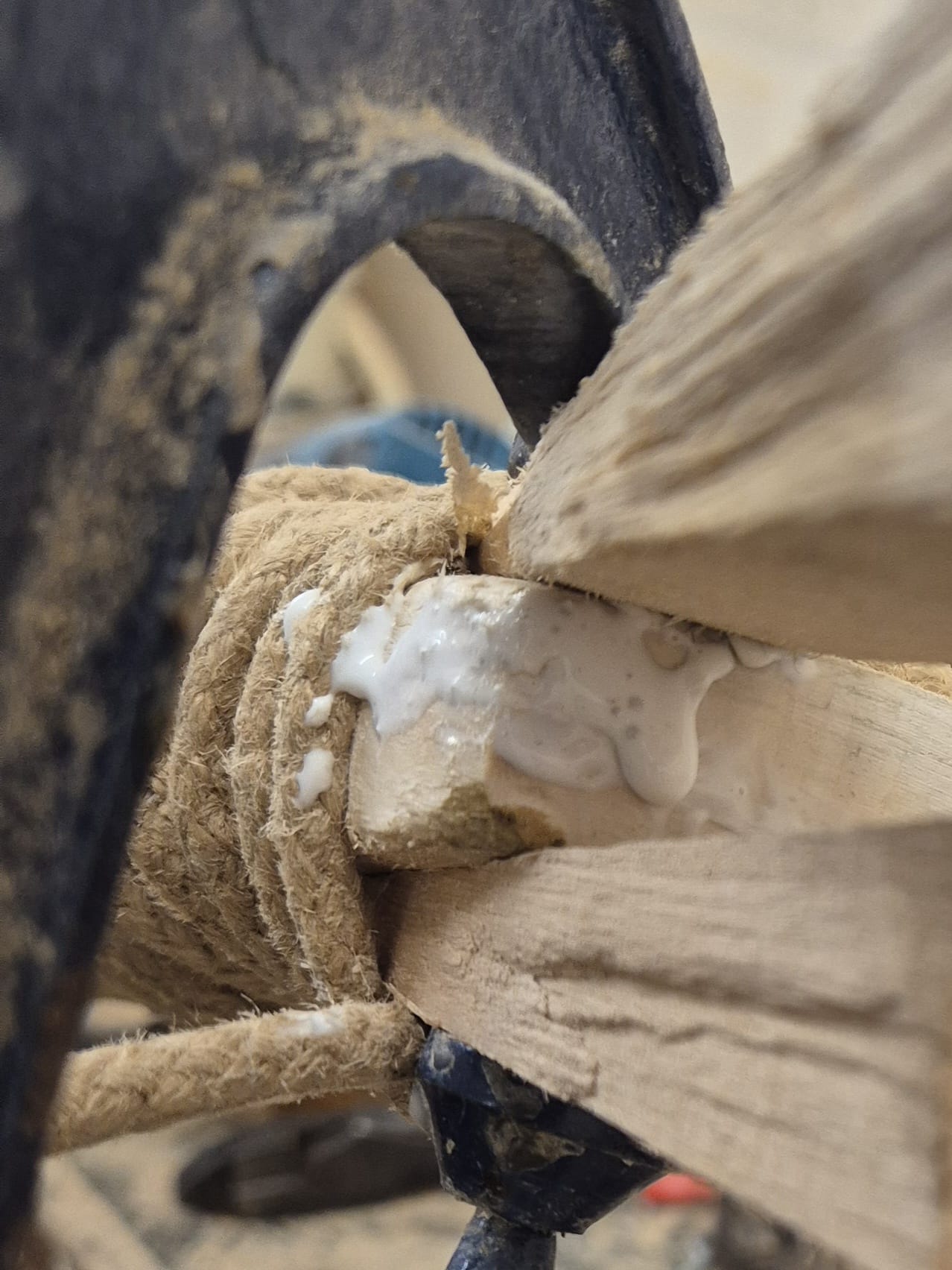 Close-up of a wood joint secured with rope and white glue, sawdust visible—ideal for Martin Berrill Sports Cricket Bat Repair - Pre Season & End of Season Clean up. Clamp in background suggests sturdy securing during repair.