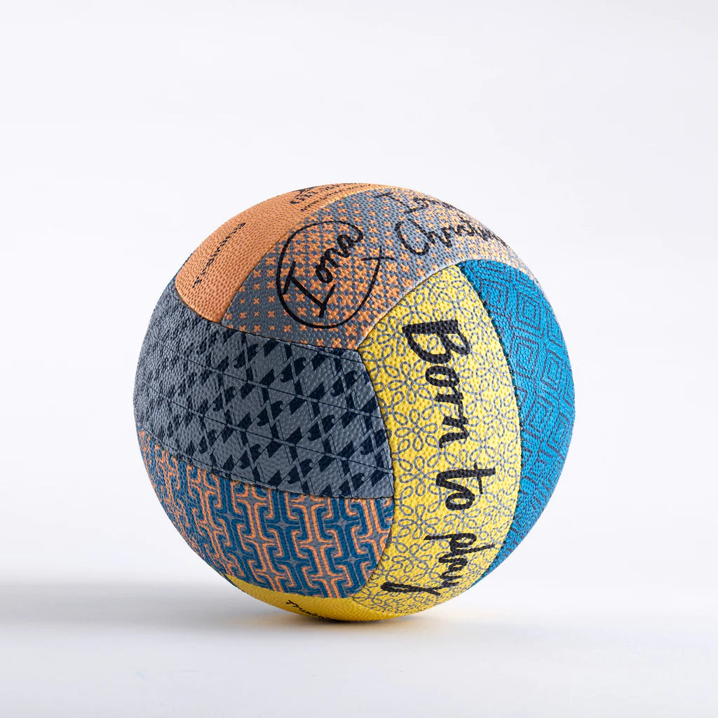 The Gilbert Ambassador Signature Netball by Gilbert is a vibrant size 5 ball with patchwork designs in blue, yellow, orange, and navy, plus bold geometric patterns and the handwritten phrase “Born to Sparkle” on a yellow strip—a standout choice.