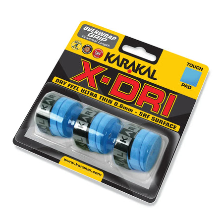 A pack of four blue Karakal X-DRI Overwrap Grips from Karakal is shown in clear packaging with yellow and black branding, featuring Dry Feel, ultra-thin 0.6mm design, and SRF Surface for superior grip performance.