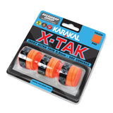 A retail pack of Karakal X-TAK Overwrap Grip by Karakal includes four ultra-thin, orange racket grips with “KARAKAL” branding, displayed on a backing card.