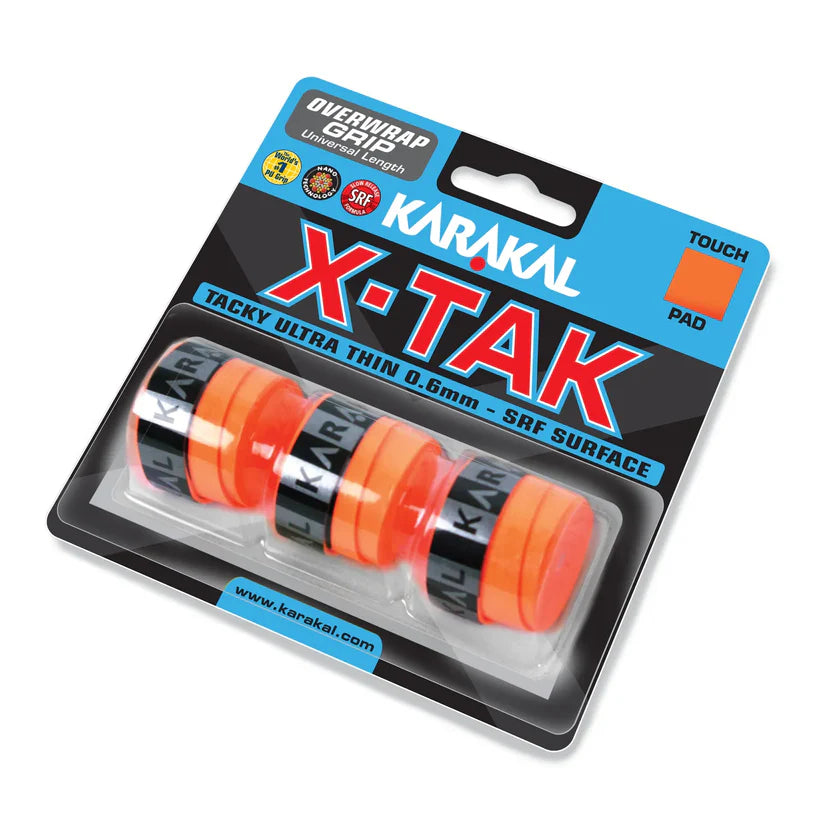 A retail pack of Karakal X-TAK Overwrap Grip by Karakal includes four ultra-thin, orange racket grips with “KARAKAL” branding, displayed on a backing card.