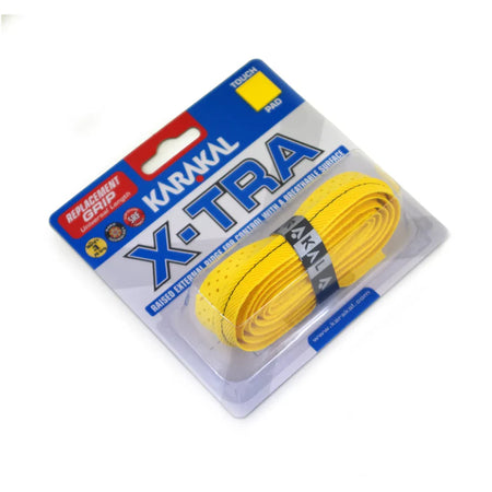 The Karakal X-TRA Grip, a yellow cushioned replacement grip for sports rackets, comes coiled and secured with a black band in clear plastic packaging, offering extra absorbency and comfort.