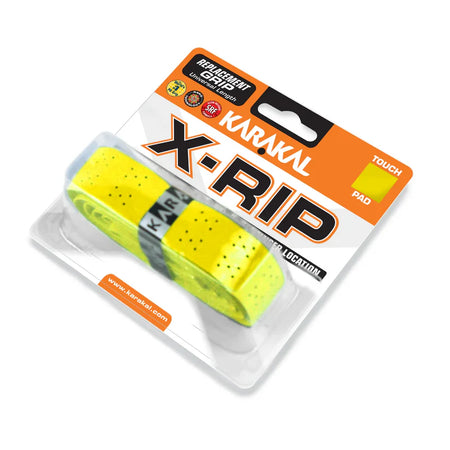 A package of Karakal X-RIP Grip in yellow is visible through a clear plastic case, showing the universal racket grip with bold orange, black, and white Karakal branding.