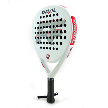 The Karakal Padel FF 365, a white padel racket by Karakal, features a teardrop-shaped head, black grip, circular holes, bold black and red “FF” design, and an attached wrist strap.