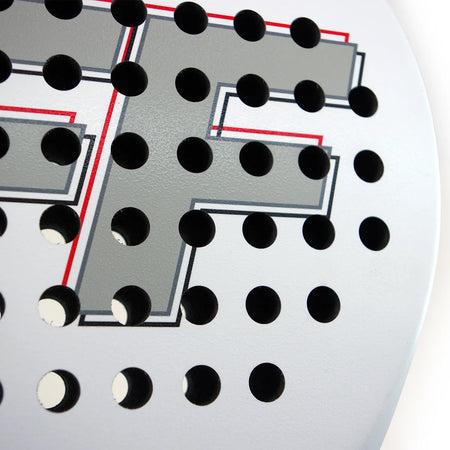 Close-up of the white surface of the Karakal Padel FF 365, showing evenly spaced round holes and a large gray "F" outlined in red and black, hinting at its distinctive teardrop-shaped head.
