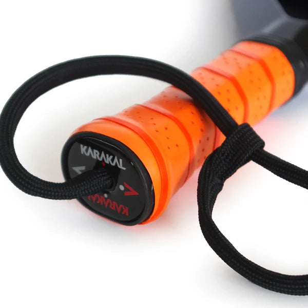 Close-up of the Karakal Air Lite 345 Padel - Orange featuring a lightweight graphite build, orange handle, black wrist strap, and the Karakal brand name on the end cap.