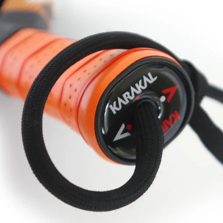 Close-up of the Karakal Air Lite 345 Padel - Orange handle shows its black strap and visible Karakal branding on the end cap, emphasizing its lightweight graphite build.