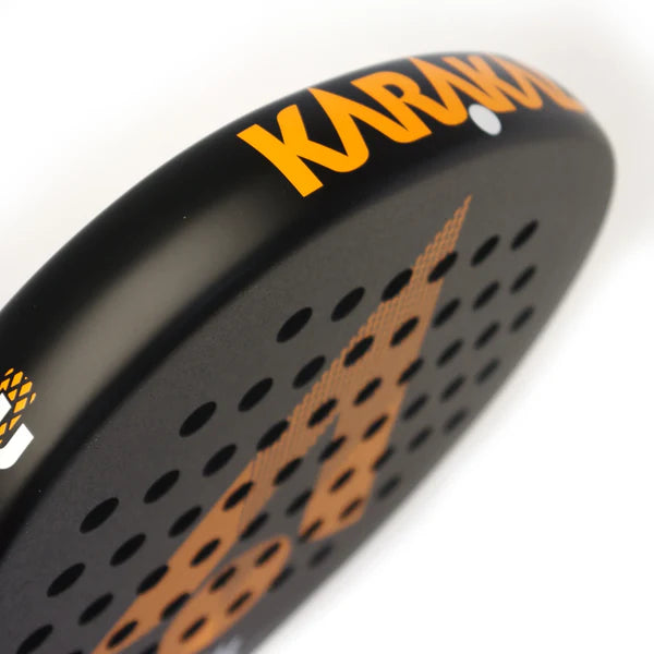 Close-up of the Karakal Air Lite 345 Padel - Orange by Karakal, featuring a lightweight graphite frame with bold orange branding and a striking pattern of dots and lines on its black face.