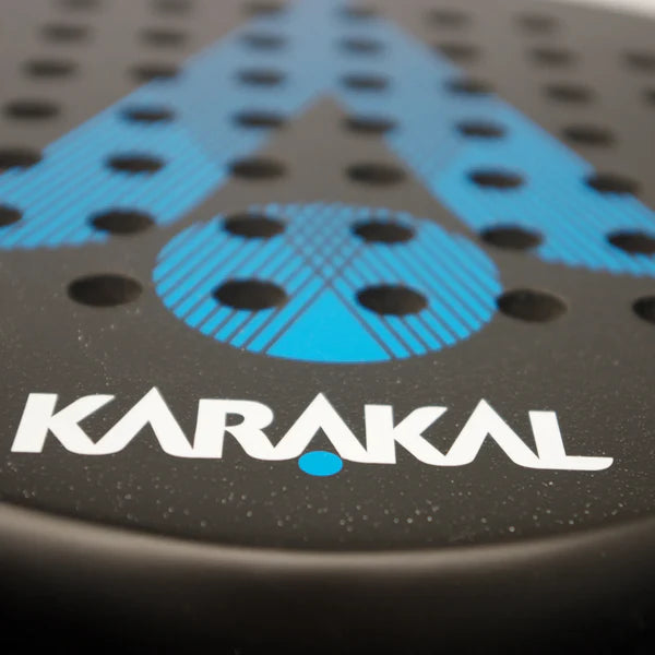 Close-up of the Karakal Air Lite 345 Padel - Blue by Karakal, showing its lightweight graphite build, black frame with blue accents, multiple holes, and bold white KARAKAL branding near the bottom.