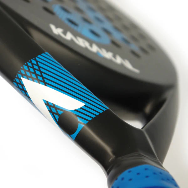Close-up of the Karakal Air Lite 345 Padel - Blue by Karakal, highlighting its lightweight graphite build, with the handle and part of the stylized frame visible and "KARAKAL" partly shown on the surface.