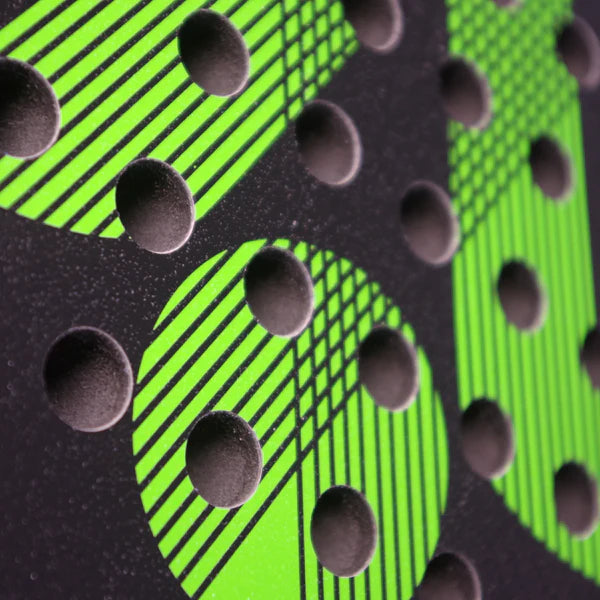 Close-up of a textured surface with bright green circular patterns and diagonal lines, topped with raised black dots—echoing the lightweight graphite design on the Karakal Air Lite 345 Padel - Green by Karakal.