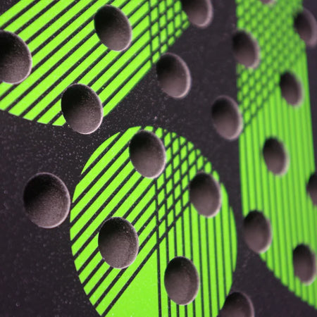 Close-up of a textured surface with bright green circular patterns and diagonal lines, topped with raised black dots—echoing the lightweight graphite design on the Karakal Air Lite 345 Padel - Green by Karakal.