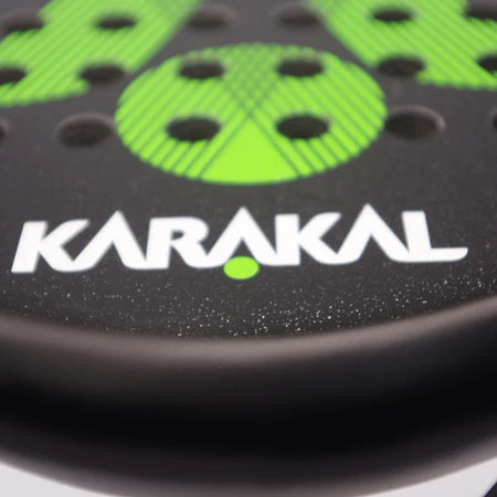 Close-up of the Karakal Air Lite 345 Padel - Green racket, made from lightweight graphite with green details, circular holes, and the KARAKAL brand name in bold white lettering.