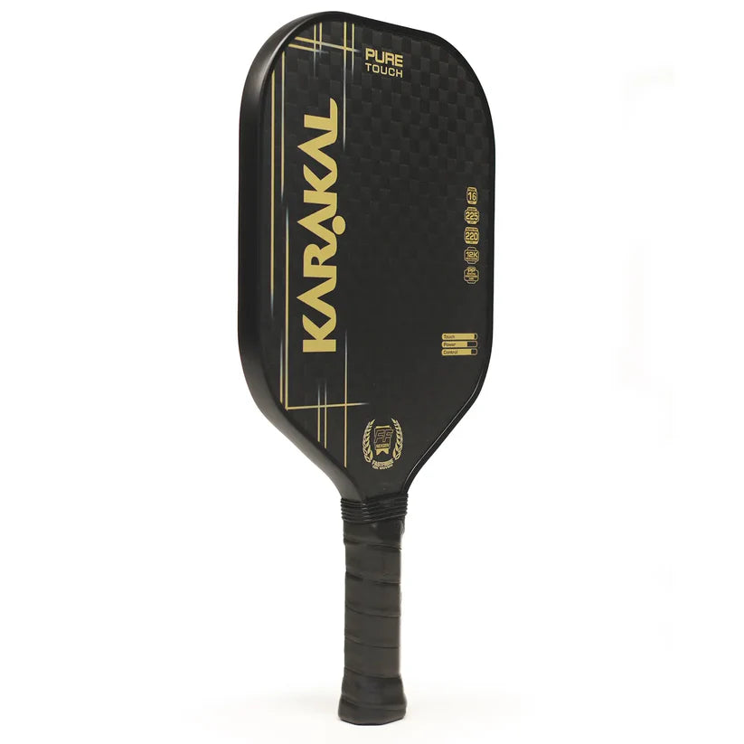 The Karakal Pure Touch Gold Pickleball Paddle by Karakal features a black design with gold accents, a power core, textured surface, and black grip handle, displayed against a white background.