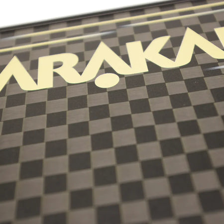 Close-up of the Karakal Pure Touch Gold Pickleball Paddle by Karakal, featuring a brown and black checkerboard pattern with part of the word "Karakal" in large cream-colored letters across the top.