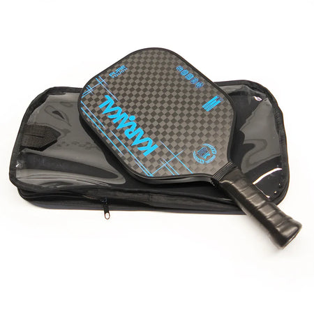 The Karakal Pure Touch Blue Pickleball Paddle by Karakal, featuring blue and black carbon fiber with a textured surface and honeycomb power core, is shown resting on a black zippered carrying case.