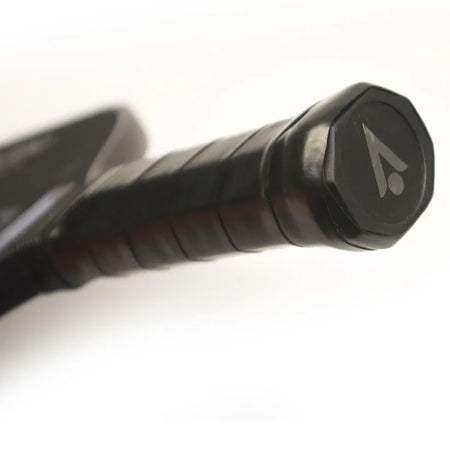 Close-up of the Karakal Tracer Control Pickleball Paddle's handle, wrapped in a textured grip for spin control, with the Karakal logo—an angled A and dot—on the butt cap.