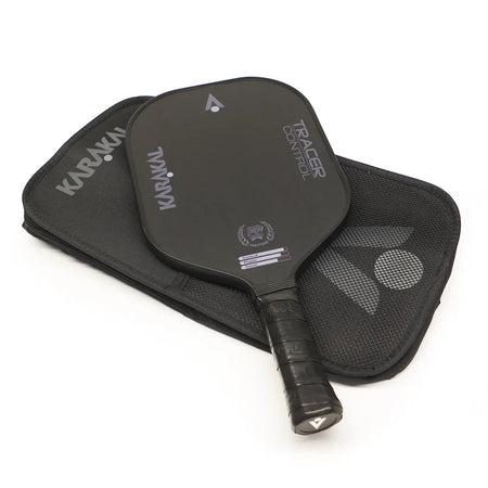 The Karakal Tracer Control Pickleball Paddle, designed for superior spin control with a honeycomb power core, is shown in black resting on a matching black carrying case featuring the Karakal brand name.