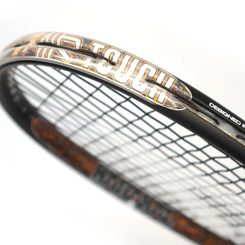 Close-up of the Karakal Air Touch 2.1 Squash Racket by Karakal, a lightweight racket made from high modulus graphite, featuring the word TOUCH in bold white and gold on its frame and black strings strung tightly.