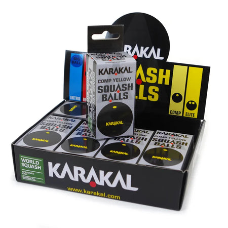 A display box of Karakal Yellow Dot Squash Balls by Karakal, with each box labeled "Comp Yellow Squash Balls." The WSF approved packaging has a black and yellow design featuring the Karakal logo.