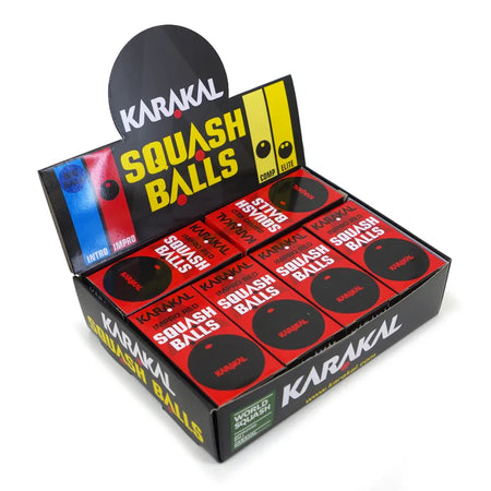 A display box of Karakal Red Dot Squash Balls by Karakal, in red and black packaging. WSF approved and ideal for intermediate players, the box holds multiple balls and features color codes on the back panel.