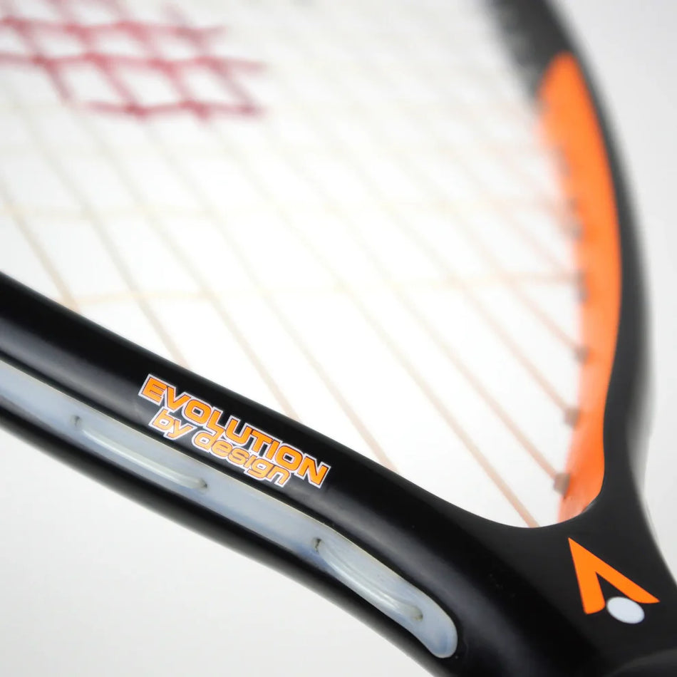 Close-up of the Karakal CRX-Hybrid 2.1 Racketball Racket by Karakal, featuring a black and orange graphite composite frame, visible strings, and "Evolution by design" printed on the racket.