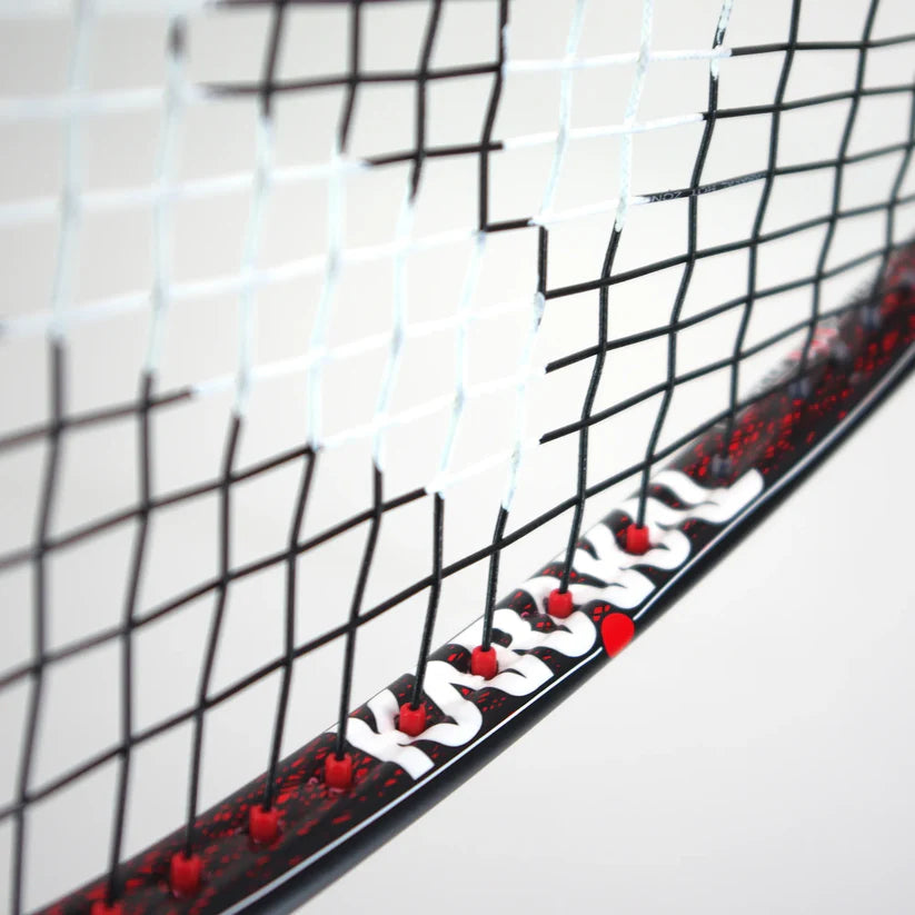 Close-up of the Karakal Air Power 2.1 Squash Racket, featuring black strings over an oval high modulus graphite frame with white grommets and red accents along the edge, shown against a plain background.