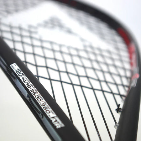 Close-up of the Karakal Air Power 2.1 Squash Racket by Karakal, featuring black strings and a high modulus graphite frame with a white specifications label in black text. The background is plain and blurred.
