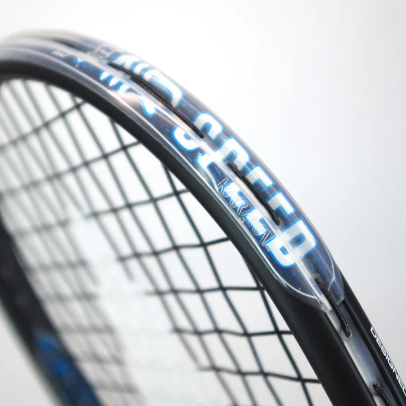 Close-up of the Karakal Air Speed 2.1 Squash Racket by Karakal, featuring black high modulus graphite, blue and white "SPEED" lettering on the frame, visible strings, and part of the racket’s edge against a plain light background.