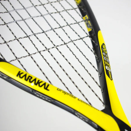 Close-up of the Karakal Raw 120 2.1 Squash Racket in yellow and black, highlighting its strings, frame details, and side specs—an ultra-light graphite racket by Karakal designed for precision and speed.