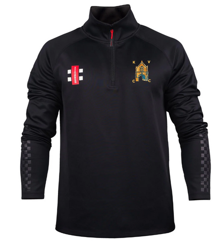 The Gray Nicolls Kingswood Village CC Pro Thermo Fleece is a black long-sleeve athletic pullover featuring a red 1/4 zip, multicolored club crest left chest, red rectangular logo right chest, and checkered detail on lower sleeves.